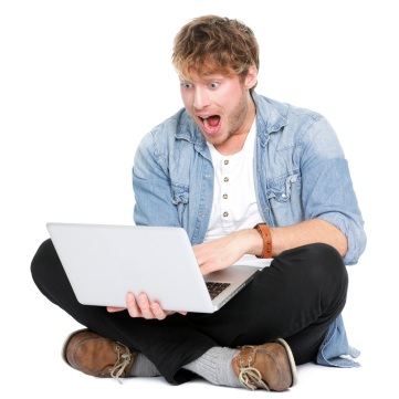 man staring excitedly at computer screen